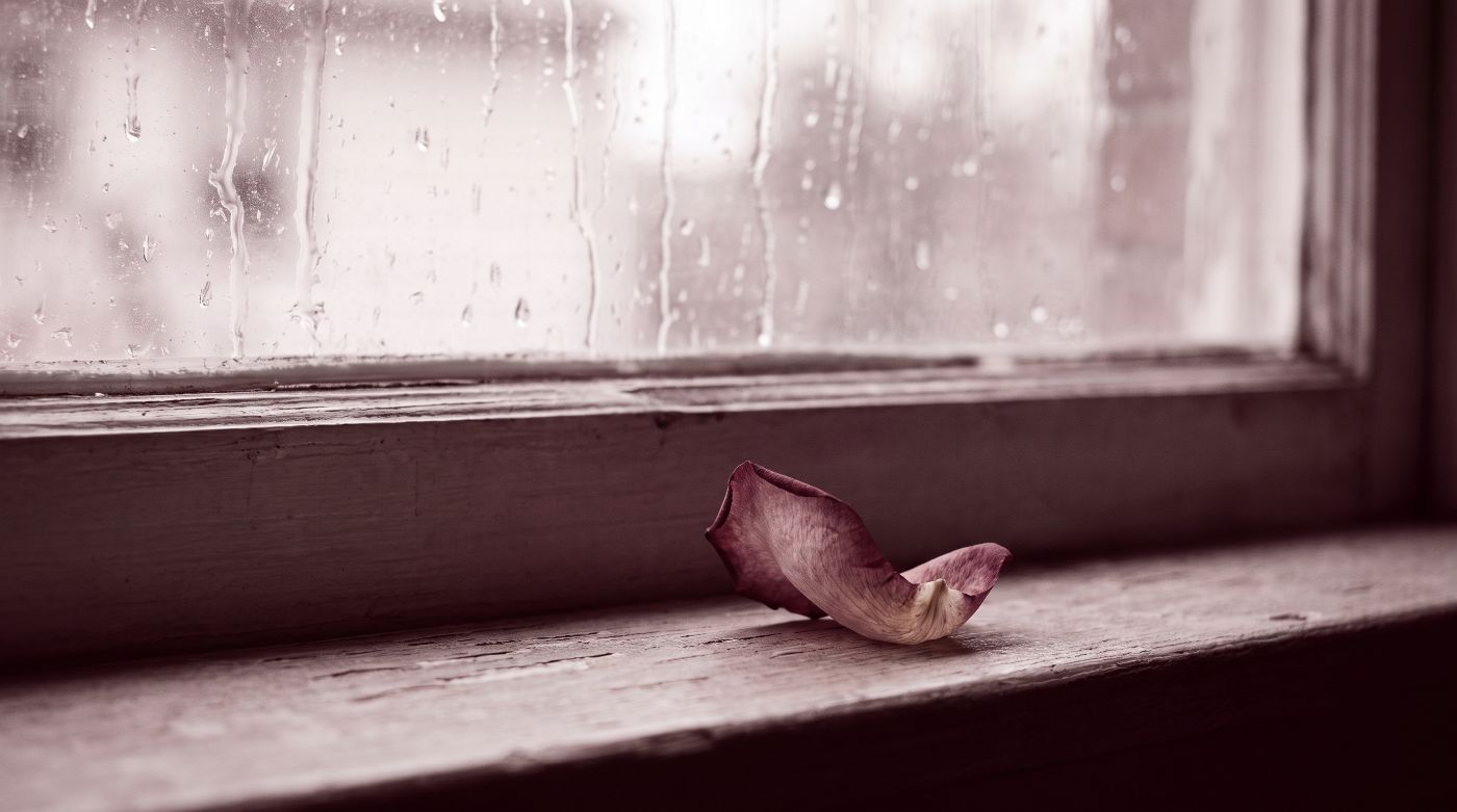 A woman looking out a rain-streaked window